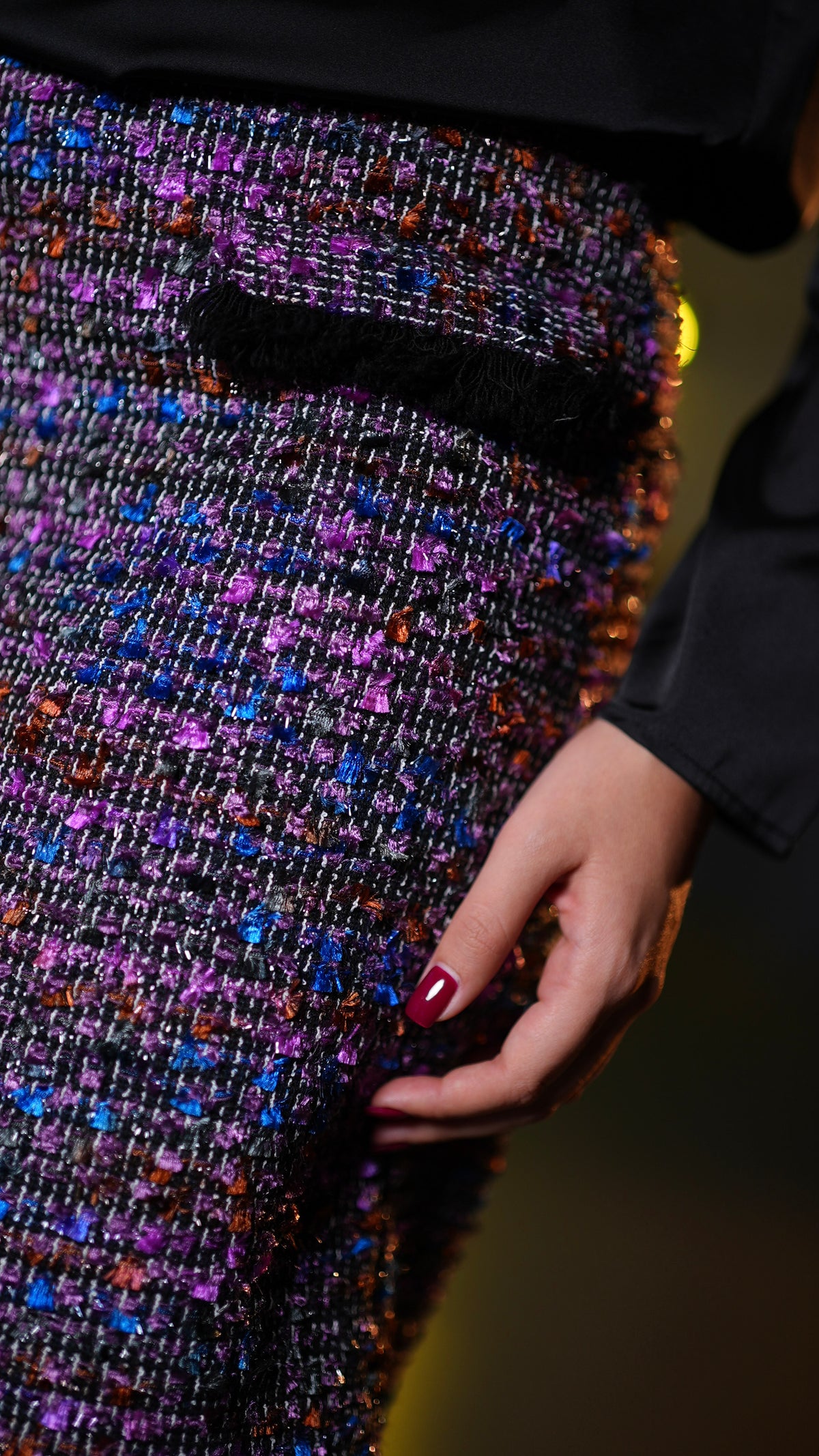 A sparkly multicolor tweed skirt with purple, blue, orange, and pink flecks.