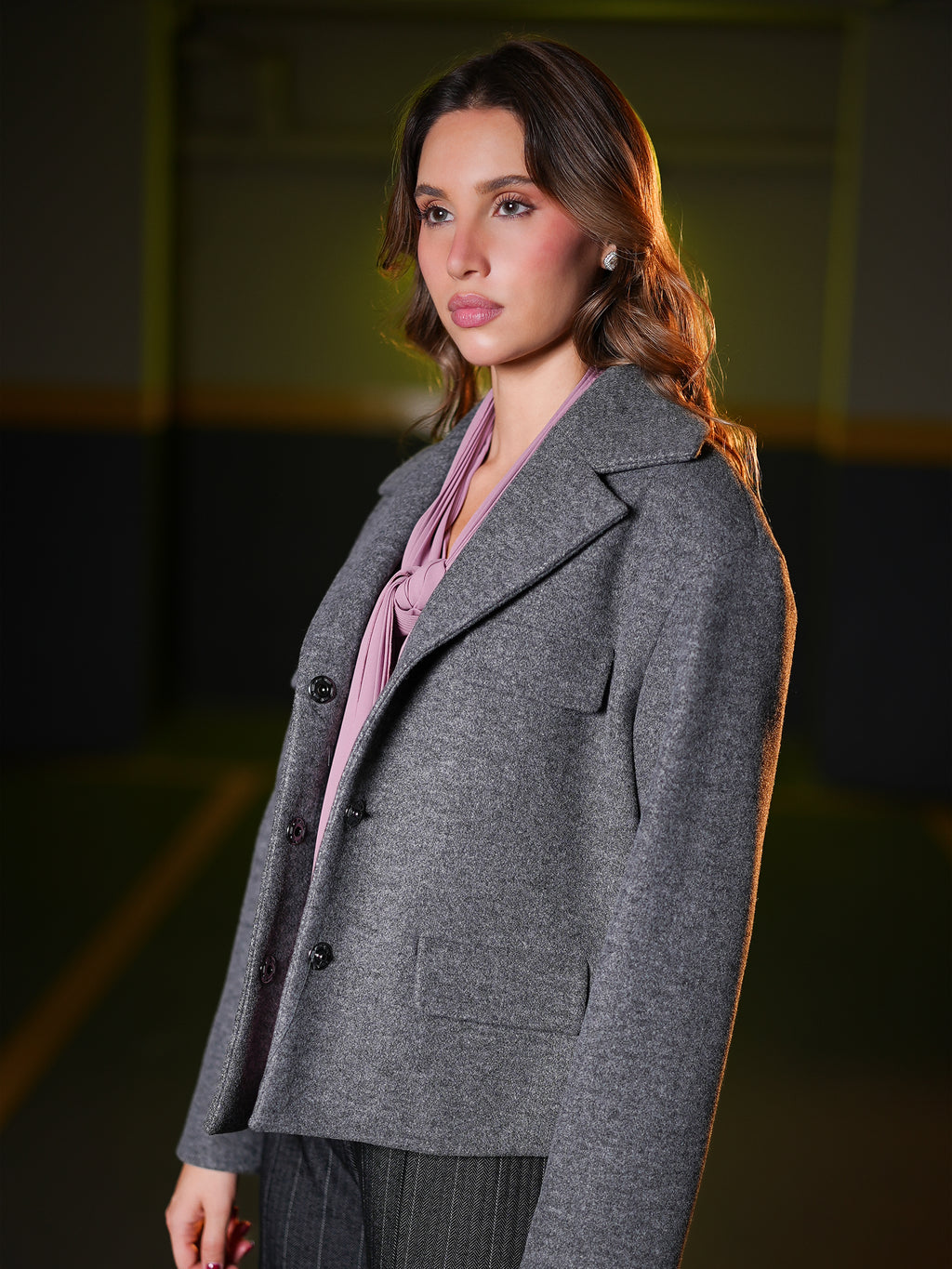 Side view of the grey wool jacket showing wide notched lapels and button front