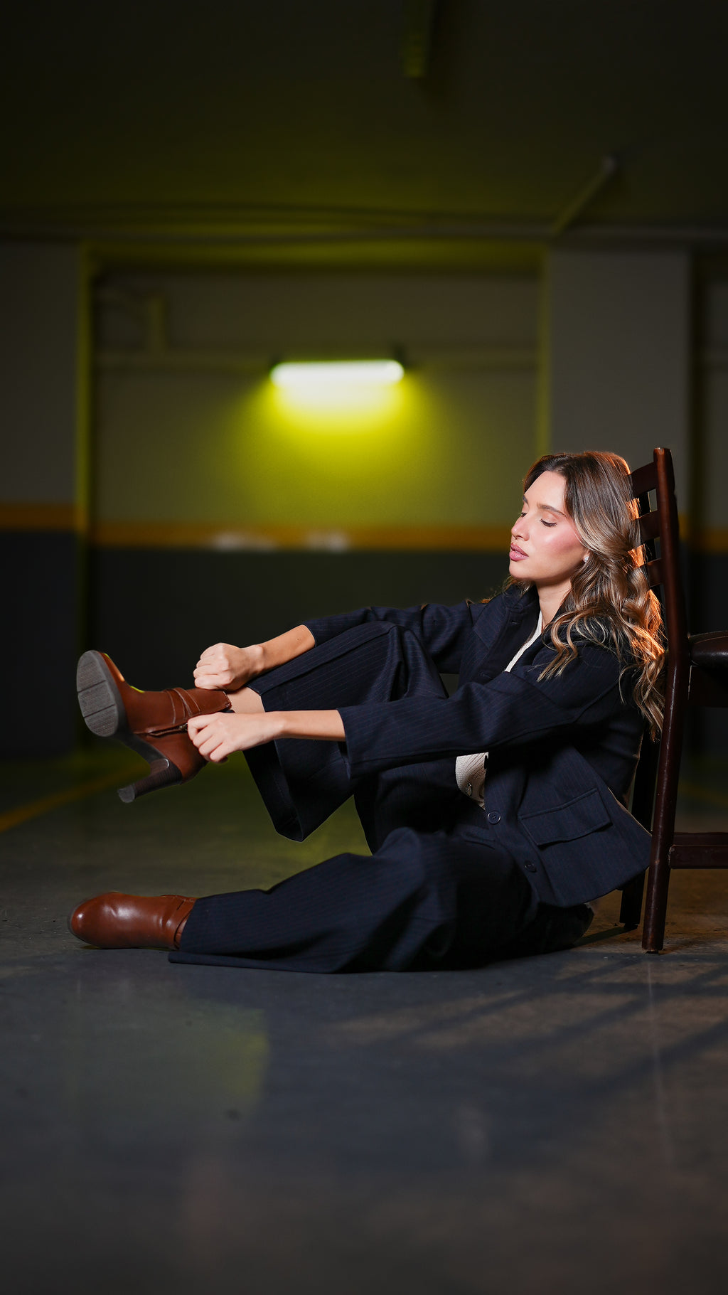 Dark navy blazer and trousers set, seated reclined pose with legs extended