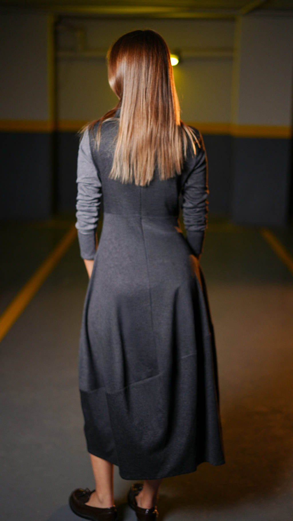 “Back view of the Duo Grey Dress showing long sleeves and a flared midi skirt.”