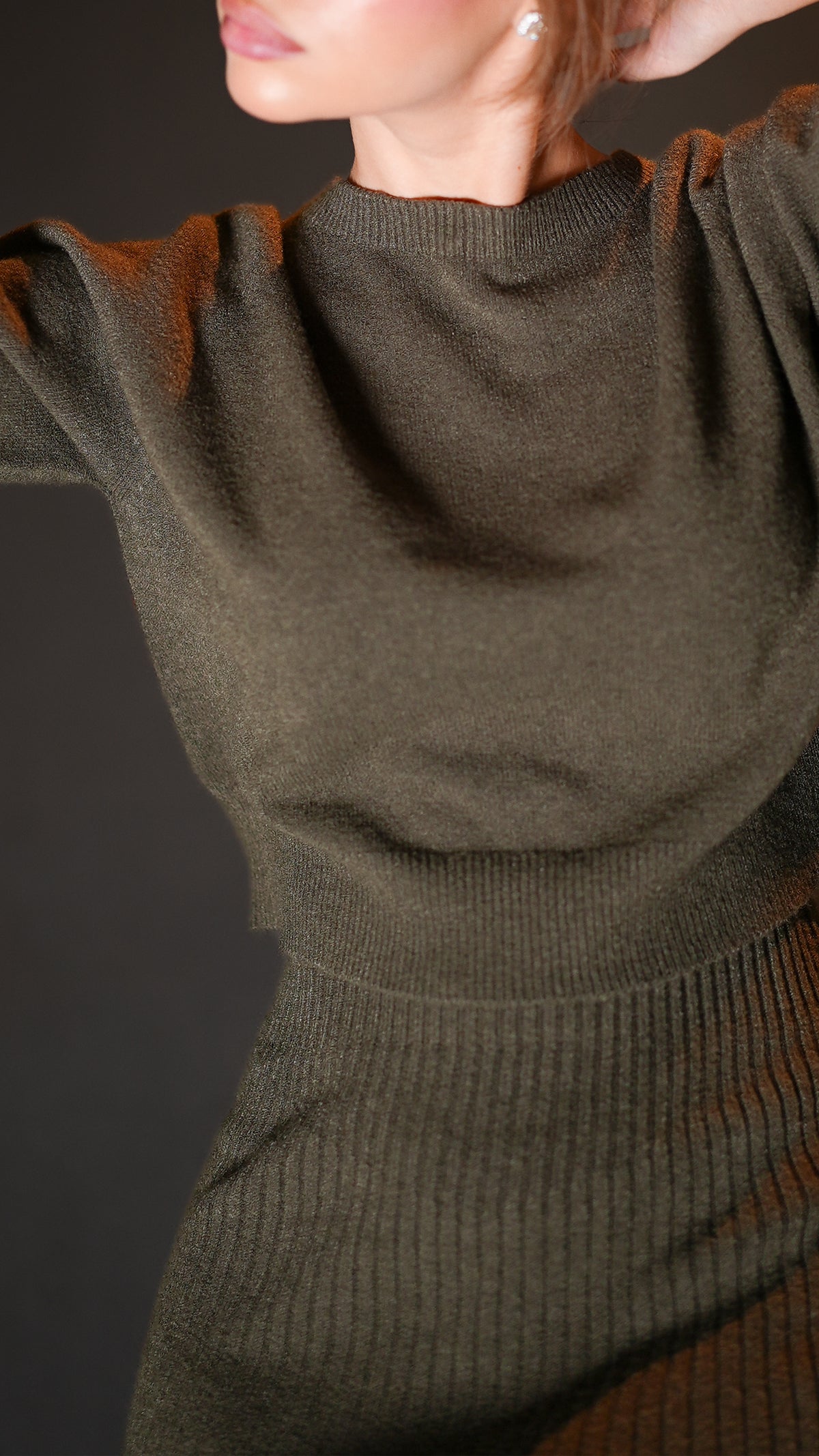 Close-up of dark olive knit neckline and ribbed skirt texture