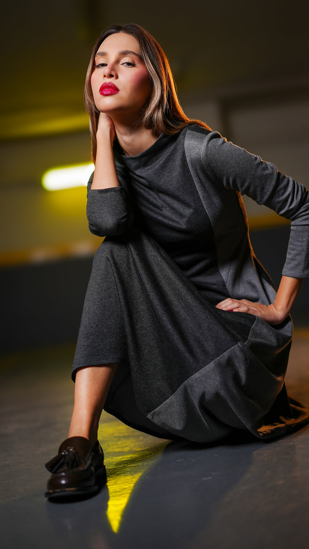 “Full-length seated view of the Duo Grey Dress with two-tone grey panels and a flowing midi skirt